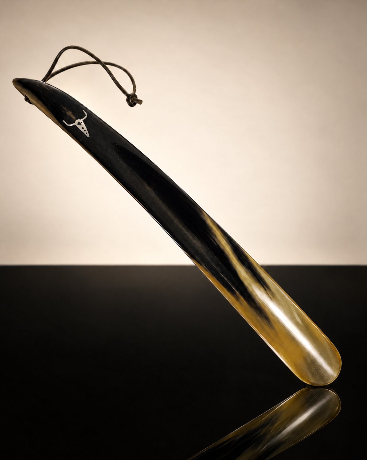 Natural horn shoehorn with leather loop, marked with the Ghost Town Ranch Bull